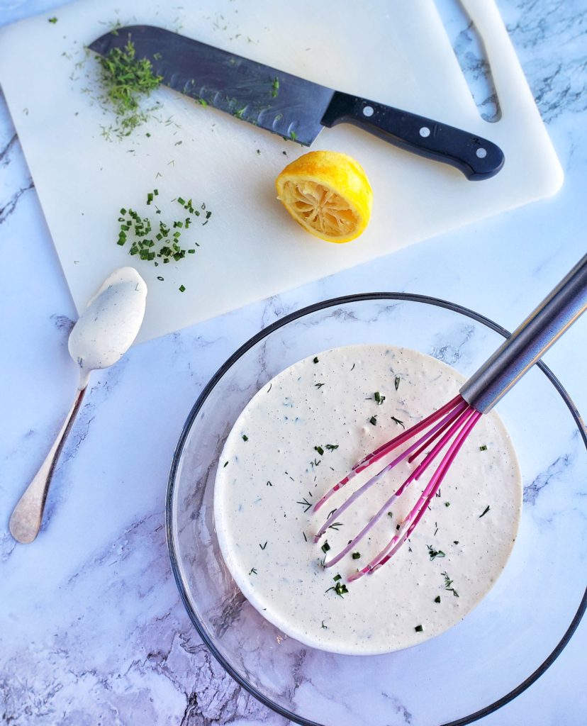 Homemade Buttermilk Ranch Dressing In A Bowl Next To Cutting Board